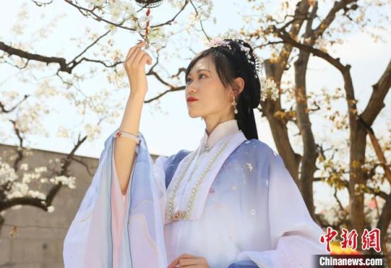 圖為蘭州青年身穿漢服在百年梨園賞景?！「哒?攝
