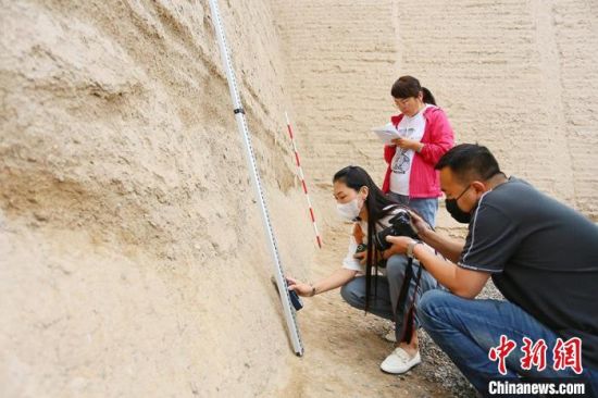 科技保護讓長城價值的真實性和完整性得到有效延續(xù)和傳承。圖為文物工作者正在測量關城的相關數(shù)據(jù)?！「哒?攝