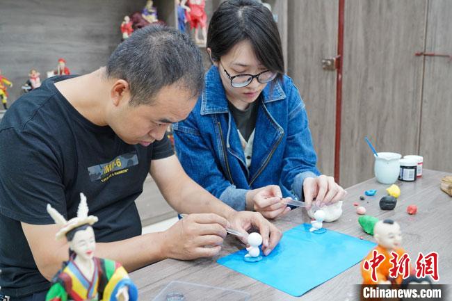 <a target='_blank'  data-cke-saved- >中新社</a>記者(右)現(xiàn)場(chǎng)體驗(yàn)面塑制作過(guò)程?！￡悹?zhēng)強(qiáng) 攝