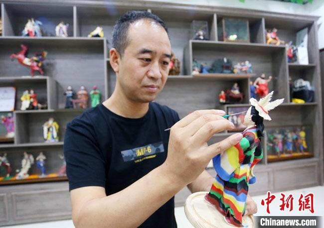 圖為安秋平正在創(chuàng)作代表隴南文縣民俗的《白馬人》作品?！「哒?攝