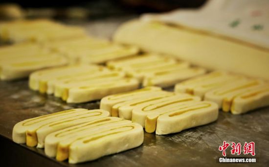 圖為面劑被涂上胡麻油，切成條狀用作月餅的花型制作。張文 攝