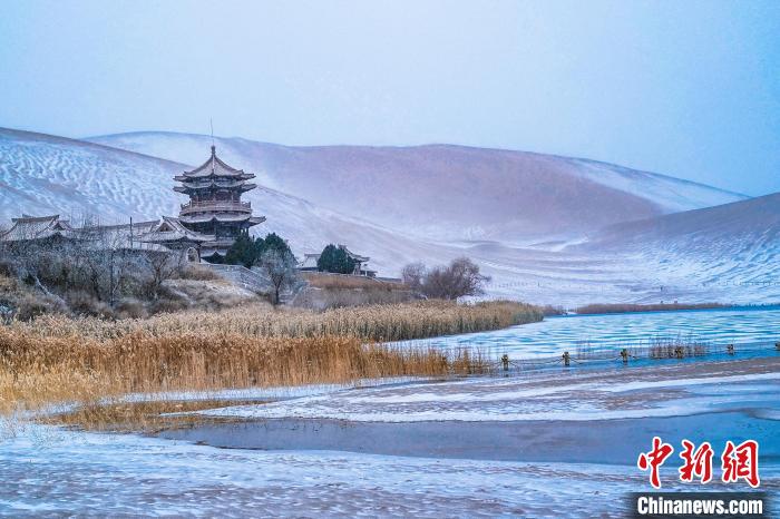 2021年11月28日，雪落鳴沙山月牙泉景區(qū)?！⊥醣筱y 攝