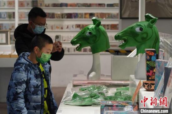 圖為“神馬來了”銅奔馬頭套吸引參觀者駐足?！【琶赖┰?攝