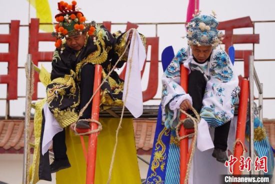 圖為“苦水高高蹺”表演者通過麻繩將腳固定在腳踏板，并在腿部纏繞六七圈?！【琶赖┰?攝