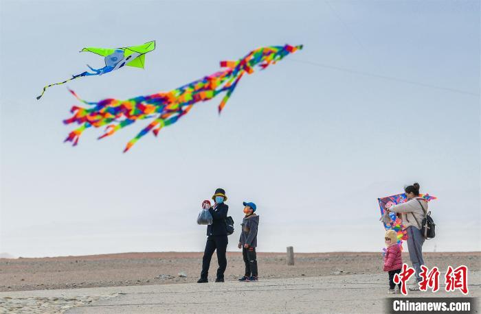 圖為孩童在父母的陪伴下放風(fēng)箏?！⊥醣筱y 攝