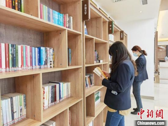 圖為在甘肅公航旅建設集團有限公司的職工書屋，職工挑選書籍。　徐雪 攝