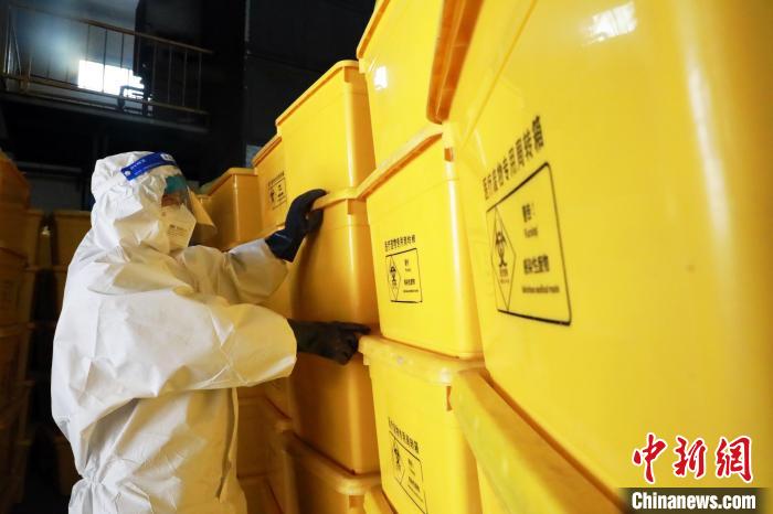 圖為工作人員搬運(yùn)醫(yī)療廢物專用周轉(zhuǎn)箱?！∥航ㄜ?攝