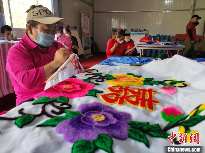 圖為婦女制作青繡?！?zhí)砀?攝