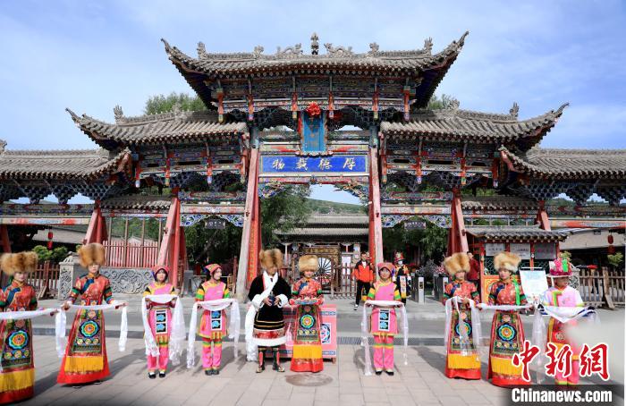 圖為身穿土族服飾的工作人員迎接訪客?！⊙Φ?攝