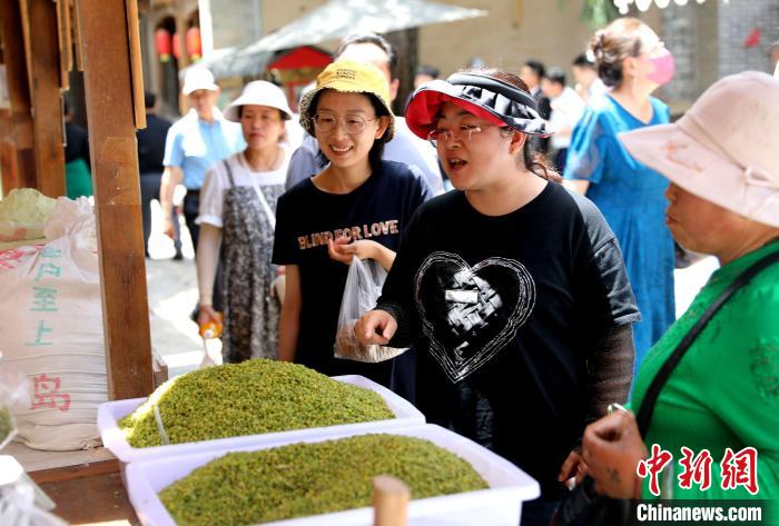 圖為民眾購(gòu)買(mǎi)青海特色小吃?！⊙Φ?攝