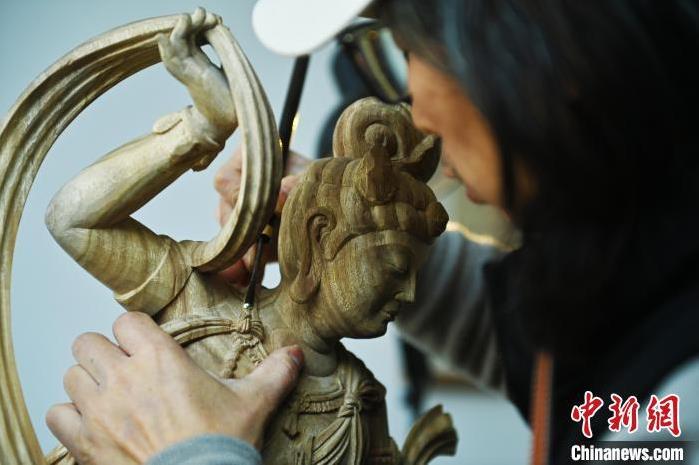 圖為季茂杰進(jìn)行敦煌元素的木雕創(chuàng)作。李亞龍 攝</p>
<p>