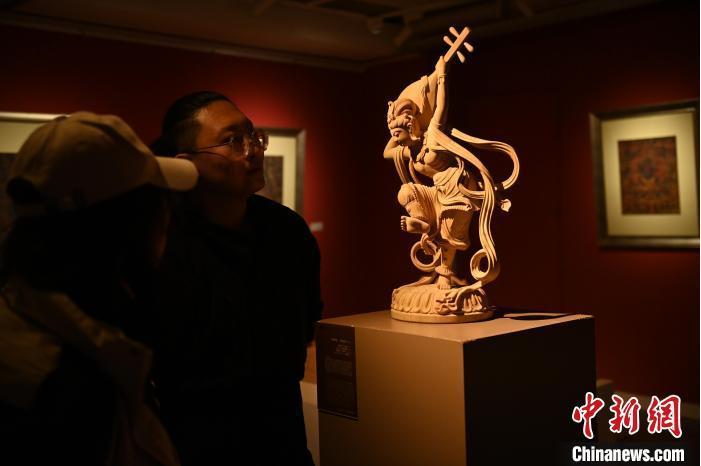 圖為季茂杰向參觀者介紹自己創(chuàng)作敦煌木雕的過程。李亞龍 攝</p>
<p>