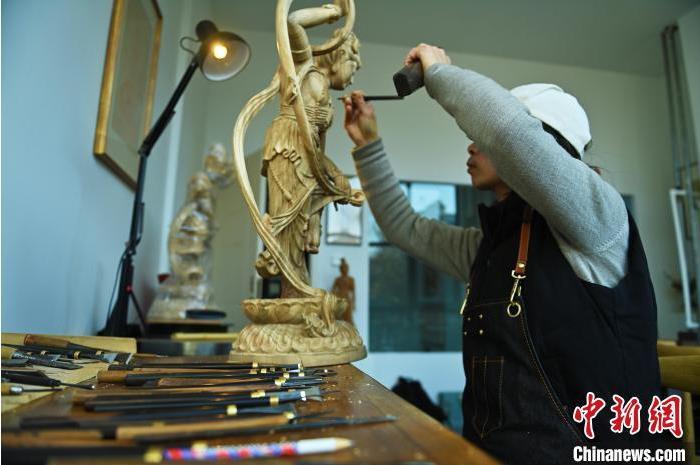 圖為季茂杰進(jìn)行敦煌元素的木雕創(chuàng)作。李亞龍 攝</p>
<p>