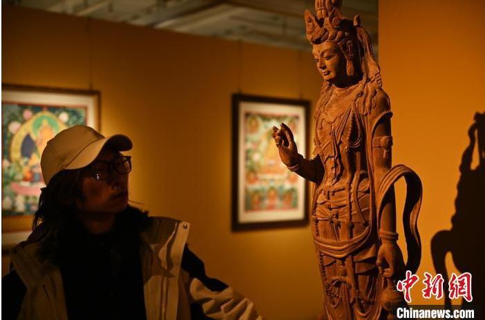 圖為季茂杰觀察自己創(chuàng)作的敦煌木雕。李亞龍 攝</p>
<p>