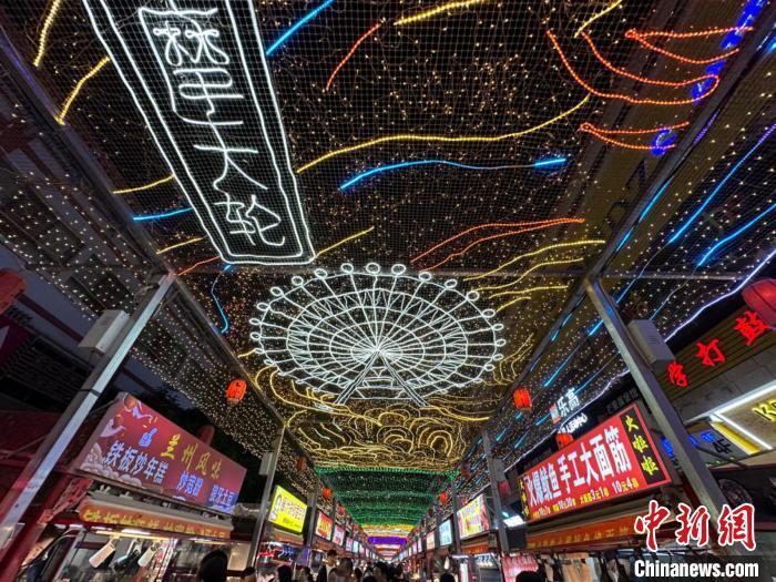 圖為明清街夜市燈光點(diǎn)亮具有武威文化元素的“摩天輪”彩燈?！〈魑牟?攝</p><p>