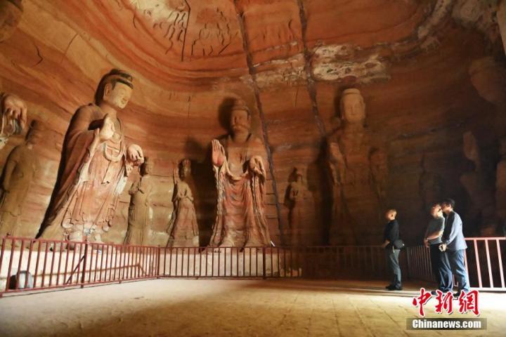 7月15日，游人參觀甘肅省平?jīng)鍪袥艽h百里石窟長(zhǎng)廊中的南石窟寺1號(hào)窟。百里石窟長(zhǎng)廊位于涇川縣境內(nèi)，由512個(gè)石窟、5眼窟中石井組成，現(xiàn)存王母宮石窟、鳳凰山石窟、南石窟寺、丈八寺石窟、羅漢洞石窟、太山寺石窟等規(guī)模較大的石窟群，還有數(shù)量眾多的小石窟群。南石窟寺開(kāi)鑿于北魏永平三年，其中1號(hào)窟屬于大型七佛窟，七佛高達(dá)6米。中新社記者 李亞龍 攝