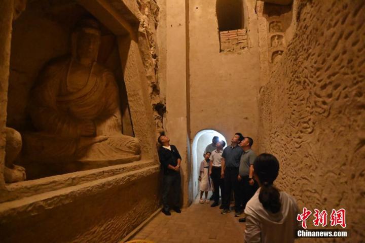 7月15日，游人參觀甘肅省平?jīng)鍪袥艽h百里石窟長(zhǎng)廊中的王母宮石窟。百里石窟長(zhǎng)廊位于涇川縣境內(nèi)，由512個(gè)石窟、5眼窟中石井組成，現(xiàn)存王母宮石窟、鳳凰山石窟、南石窟寺、丈八寺石窟、羅漢洞石窟、太山寺石窟等規(guī)模較大的石窟群，還有數(shù)量眾多的小石窟群。王母宮石窟又名千佛洞，該窟設(shè)計(jì)宏大，造像生動(dòng)，窟內(nèi)擁有造像數(shù)百尊，是較為珍貴的佛教文化歷史遺存。中新社記者 李亞龍 攝</p>
<p>