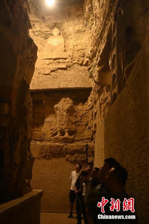 7月15日，游人參觀甘肅省平?jīng)鍪袥艽h百里石窟長(zhǎng)廊中的王母宮石窟。百里石窟長(zhǎng)廊位于涇川縣境內(nèi)，由512個(gè)石窟、5眼窟中石井組成，現(xiàn)存王母宮石窟、鳳凰山石窟、南石窟寺、丈八寺石窟、羅漢洞石窟、太山寺石窟等規(guī)模較大的石窟群，還有數(shù)量眾多的小石窟群。王母宮石窟又名千佛洞，該窟設(shè)計(jì)宏大，造像生動(dòng)，窟內(nèi)擁有造像數(shù)百尊，是較為珍貴的佛教文化遺存。中新社記者 李亞龍 攝</p>
<p>