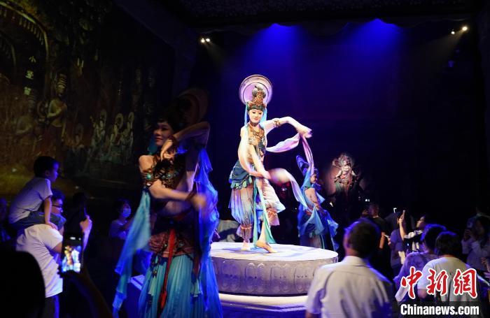 《樂動(dòng)敦煌》是全球首部洞窟式沉浸體驗(yàn)劇，利用真人與數(shù)字影像虛實(shí)交換實(shí)現(xiàn)沉浸式體驗(yàn)。圖為2023年8月28日晚，《樂動(dòng)敦煌》演出。(資料圖)中新社記者 毛建軍 攝